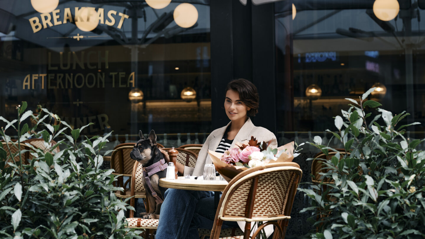 Woman sits outside at Orchard Place with her dog