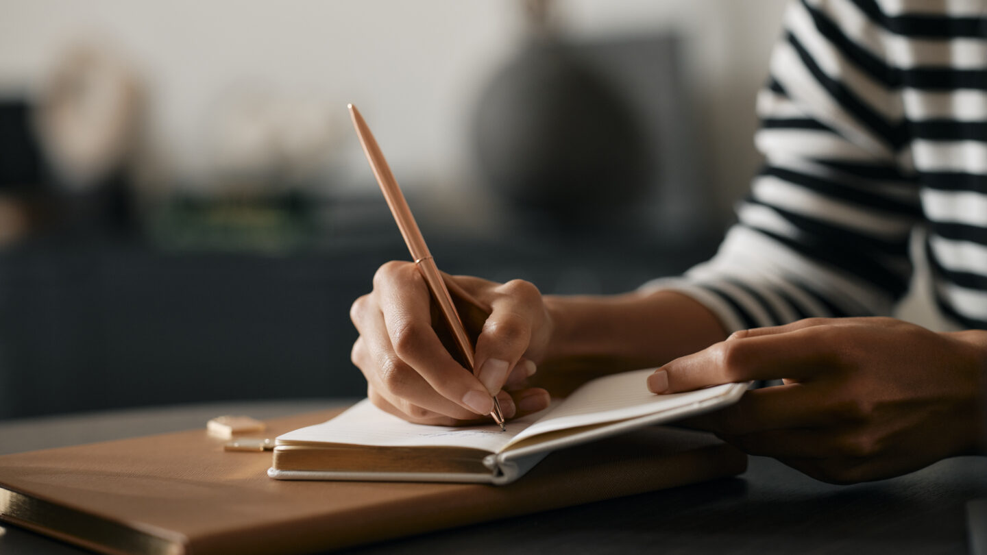 Person writes in notebook